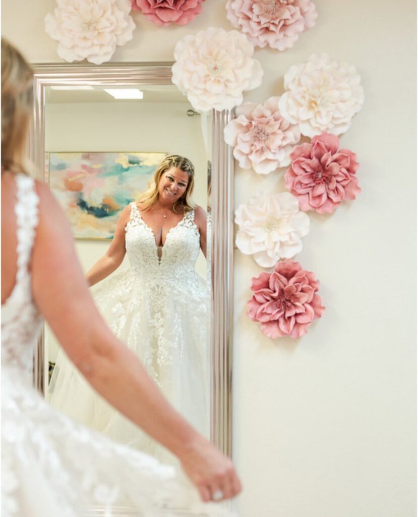 bride looking at herself in mirror at bridal seamstress shop in Olympia, WA