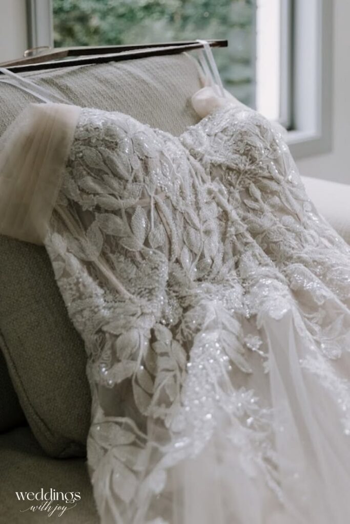 Detailed lace bridal gown from Weddings With Joy featuring floral embroidery and beading