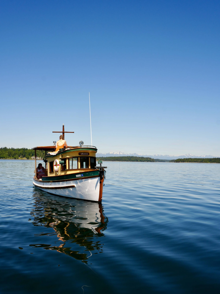 Olympia Sailing Co sailboat cruising on the water with mountains in the background